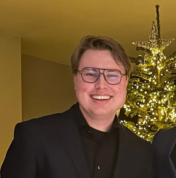 Profile picture of a very handsome young man in full suit during a christmas dinner